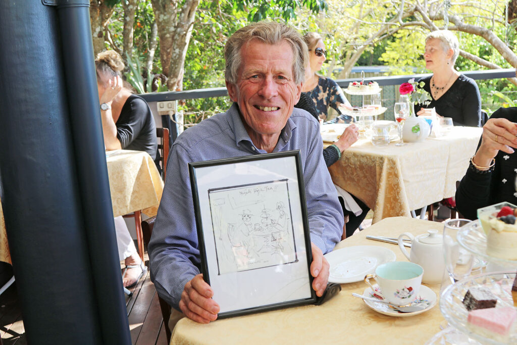 Nigel holding a sketch of ‘Nigel’s High Tea’