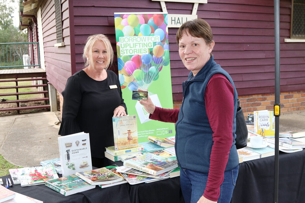 Jan Harradine from the Outreach Library Service with Vaness Rhind holding her new library card saying “I love my library card!”