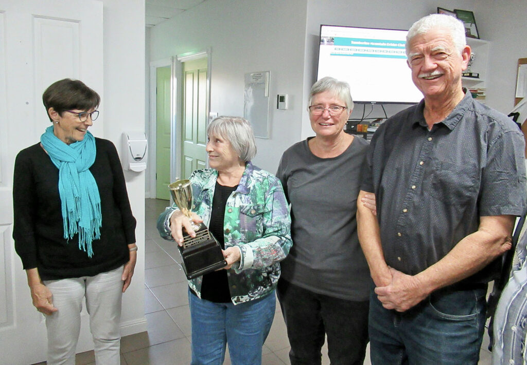 Long-time member Carole Cooke presented the cup to Di and Bill Larcombe