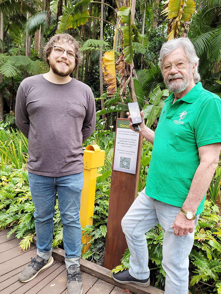 Designer Corey Davison (left) with Botanic Gardens President Denby Browning (right) & the new QR code donation sign as shown above.